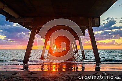 Sunset view through Glenelg jetty pylons Stock Photo