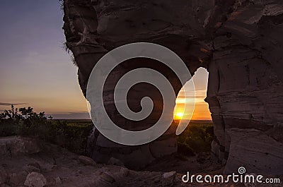 Sunset view through the rock. Arenite hole, in Jalapao, Brazil. Pedra furada. Stock Photo
