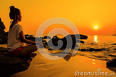 sunset yoga woman with spirituality on sea coast Stock Photo