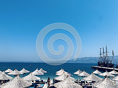 Sunshade umbrellas and deckchairs on the beautiful beach, Albania. Editorial Stock Photo