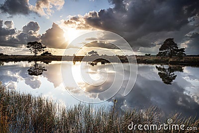 Sunshine through dramatic rain clouds over lake Stock Photo