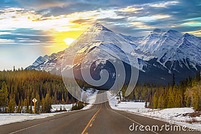 Sunshine Peeking Over A Mountain Road Stock Photo