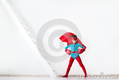 Super hero boy in red boxing gloves and a cape in the wind. Stock Photo