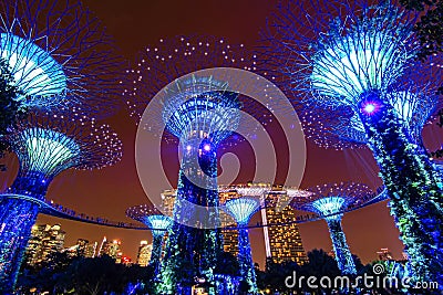 Super tree light glowing Singapore landmark Gardens by the Bay and Marina Bay Sands building with sunset twilight sky background Editorial Stock Photo