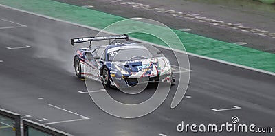 Supercar Ferrari GT racing action on wet raining asphalt straight track circuit Editorial Stock Photo