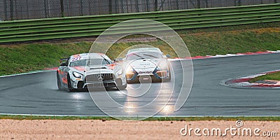 Supercar Mercedes anc Porsche racing on wet raining asphalt track circuit spraying water Editorial Stock Photo
