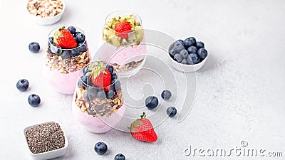 Superfoods layered pudding with granola, blueberry and strawberry in glasses. Yogurt with chia seeds, berries, kiwi and Stock Photo