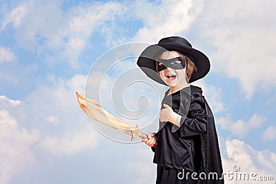 Superhero child with sward and costume on a blue sky background Stock Photo