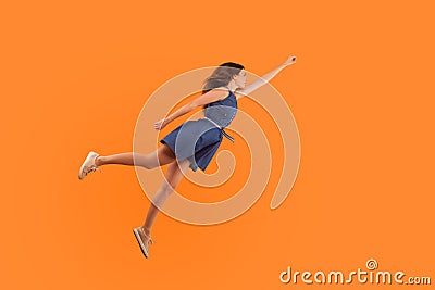 Superhero. Full length of confident motivated brunette woman in denim dress flying in air like superman Stock Photo