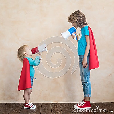 Superheroes children speaking by loudspeaker Stock Photo