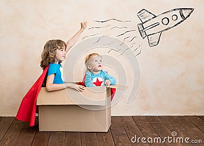 Superheroes children playing in cardboard box Stock Photo