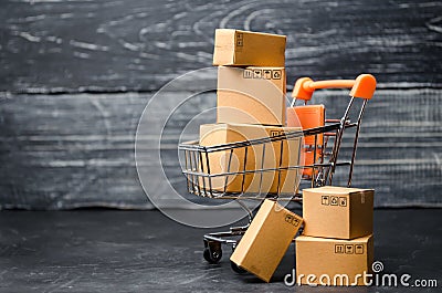 A supermarket cart loaded with cardboard boxes. Sales of goods. concept of trade and commerce, online shopping. high. delivery Stock Photo