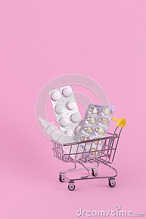A supermarket trolley full of blister pills, a lot of pills in a wheelbarrow, nasal spray. Concept: home delivery of medicines. Stock Photo