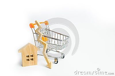 A supermarket wheelbarrow with a small house and a wooden arrow down on a white background. The fall in property prices. Decrease Stock Photo