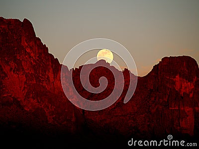 The Strawberry Supermoon Rising over the Superstition Mountains at Sunset Stock Photo