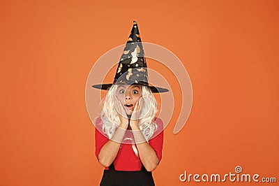 Supernatural charmer gray hair. kid enchantress orange background. happy halloween. magic fantasy. scared small girl Stock Photo