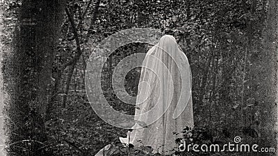 A supernatural concept of a spooky ghost with a sheet in a forest. With an old vintage photo edit Stock Photo