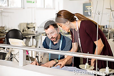 Supervisor giving advice to a tailor Stock Photo