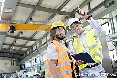 Supervisor showing something to manual worker in metal industry Stock Photo