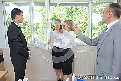 Supervisor watching lady clean windows Stock Photo