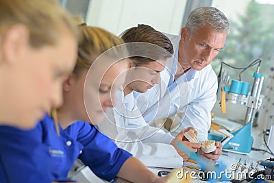 Supervisor watching trainees in dental laboratory Stock Photo
