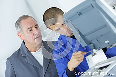 Supervisor watching young technician at work Stock Photo