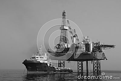 Supply vessel and drilling platform, work in progress Stock Photo