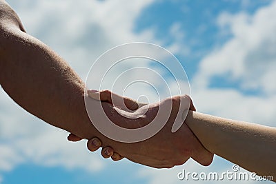 Support. Help. Friendship. Male and female hand. Together concept. Self help. Hands on sky background. People and Stock Photo