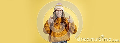 Supportive attractive 20s girl likes your idea show thumbs up positive reply affirmative answer standing pleased smiling Stock Photo