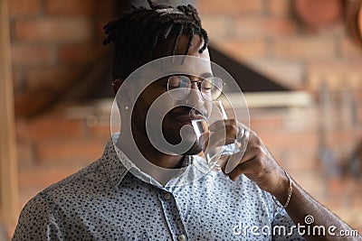 Thirsty young afro american man drink mineral aqua from glass Stock Photo