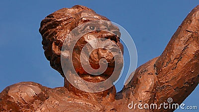 Surakarta, Indonesia, 20th June 2023, Statue of spirit of sport in a form of man holding torch against blue sky, Patung obor Editorial Stock Photo