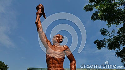 Surakarta, Indonesia, 20th June 2023, Statue of spirit of sport in a form of man holding torch against blue sky, Patung obor Editorial Stock Photo