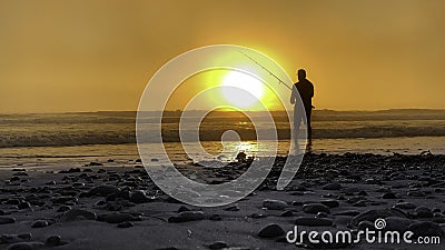 Surf fishing at sunset Stock Photo