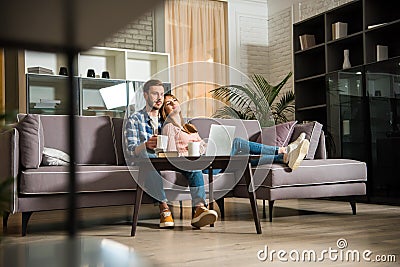 Surface level view of couple watching laptop in living room Stock Photo