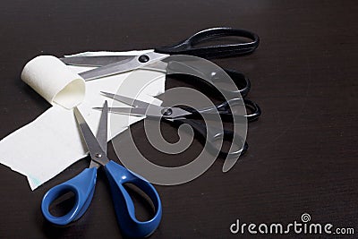 On the surface of the table are three pairs of scissors and a patch of excised tissue. Stock Photo