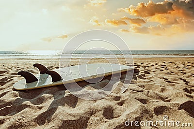 Surfboard on beach background at sunset. Stock Photo