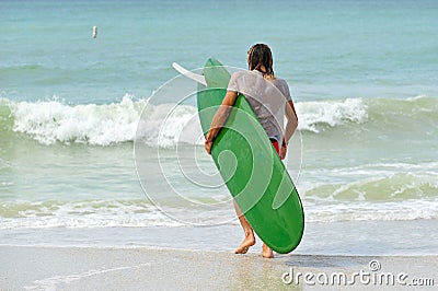 Surfer on the Beach Carryiing Surf Board Editorial Stock Photo