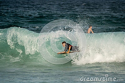 Surfer catching a wave at the beach on a sunny day at Manly Beach, Australia. Editorial Stock Photo