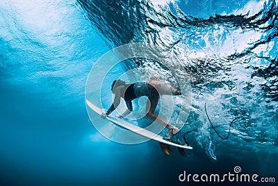 Surfer dive underwater. Surfgirl dive under wave Stock Photo
