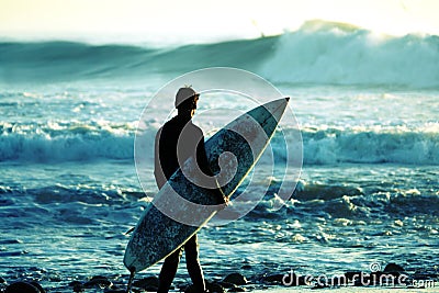 Surfer at dusk Stock Photo