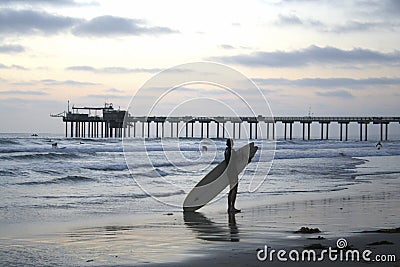 Surfer at Dusk in Front of the Scripps Pier in La Jolla, California Editorial Stock Photo