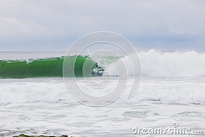 Surfer Getting Barreled on Big Wave Stock Photo