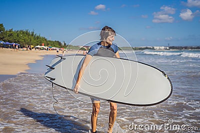 Surfer with his surfboard running to the waves Stock Photo