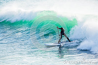 Surfer ride on stand up paddle board on ocean big wave. Stand up paddle boarding in ocean Stock Photo