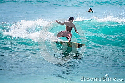 Surfer rides the waves. Dreamland Beach. Bali Editorial Stock Photo