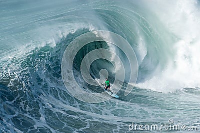 Surfer riding forward the moving foamy wave of the Atlantic Ocean at Nazare, Portugal Editorial Stock Photo