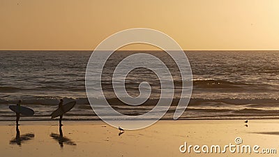 Surfer silhouette, pacific ocean beach sunset. People enjoy surfing. Oceanside, California USA Editorial Stock Photo