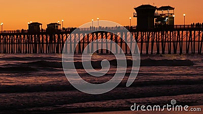 Surfer silhouette, pacific ocean beach sunset. People enjoy surfing. Oceanside, California USA Editorial Stock Photo