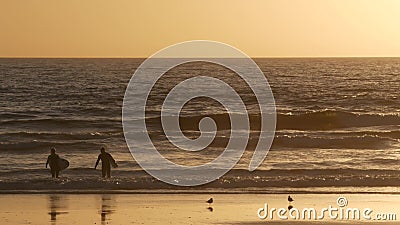 Surfer silhouette, pacific ocean beach sunset. People enjoy surfing. Oceanside, California USA Editorial Stock Photo