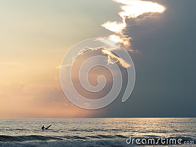 Surfer waiting for ocean waves in a overcast evening Stock Photo